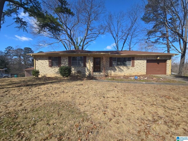 single story home featuring a garage, brick siding, and a front lawn