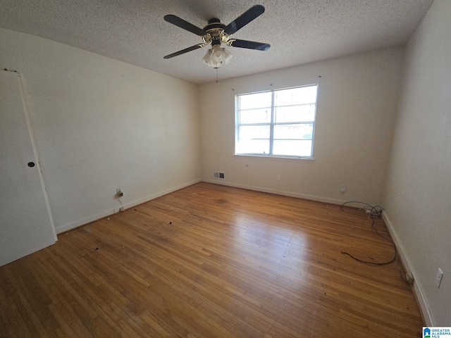 unfurnished room featuring visible vents, ceiling fan, light wood-style flooring, and a textured ceiling