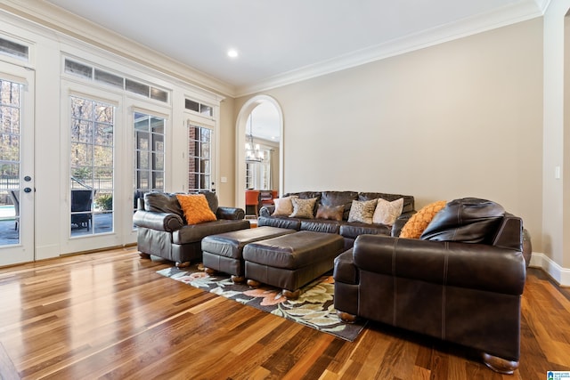 living room featuring a chandelier, hardwood / wood-style flooring, and ornamental molding