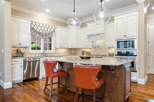 kitchen with white cabinetry, dark wood-type flooring, a kitchen island, and stainless steel appliances