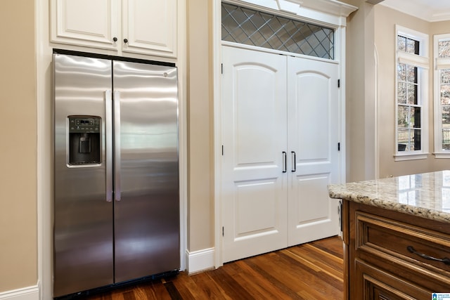 kitchen featuring stainless steel fridge, dark hardwood / wood-style flooring, light stone countertops, and ornamental molding