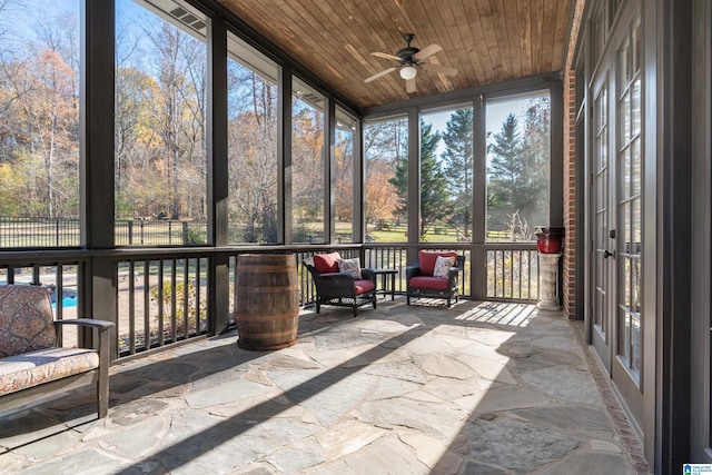 unfurnished sunroom featuring ceiling fan and wooden ceiling