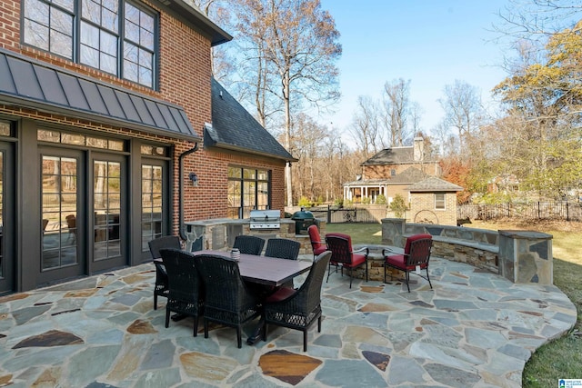 view of patio with a grill, exterior kitchen, and an outdoor stone fireplace