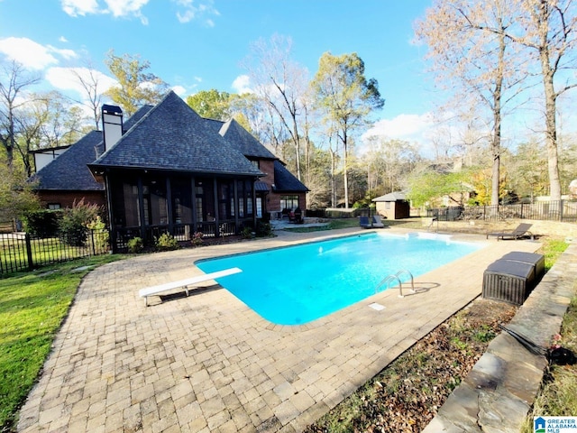 view of pool featuring a sunroom, a diving board, and a patio area