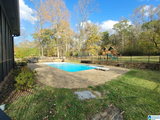 view of pool with a diving board and a playground