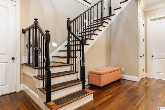 stairway featuring wood-type flooring and ornamental molding