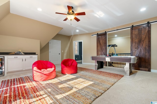 playroom featuring lofted ceiling, light carpet, wine cooler, ceiling fan, and a barn door