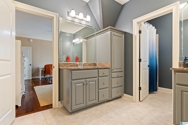 bathroom with vanity, a shower with curtain, crown molding, vaulted ceiling, and hardwood / wood-style flooring