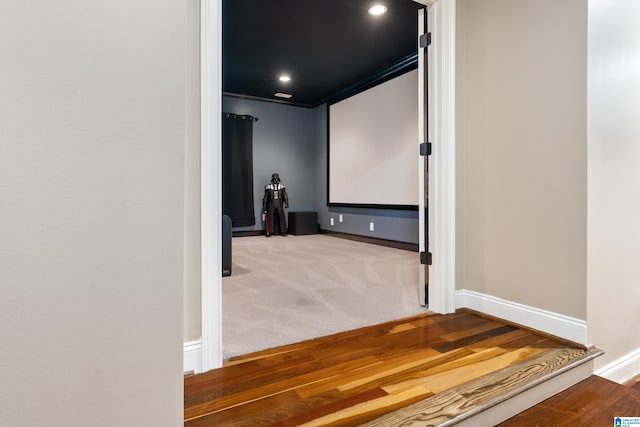 carpeted home theater room with crown molding