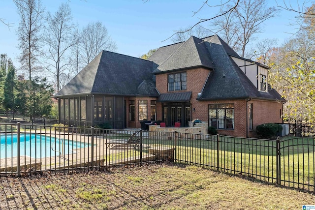 back of property featuring a fenced in pool, a lawn, and a sunroom