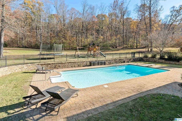 view of swimming pool featuring a playground, a diving board, a patio, and a trampoline