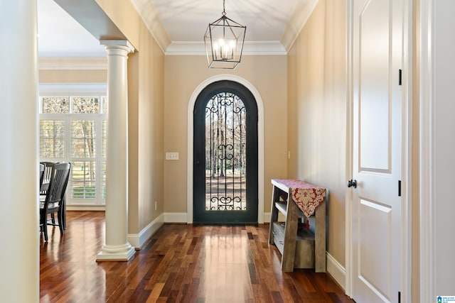 foyer with a chandelier, dark hardwood / wood-style floors, decorative columns, and crown molding