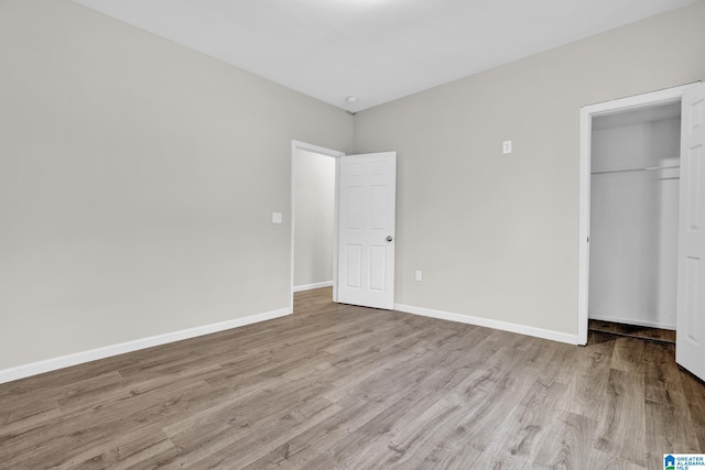 unfurnished bedroom featuring light hardwood / wood-style flooring and a closet