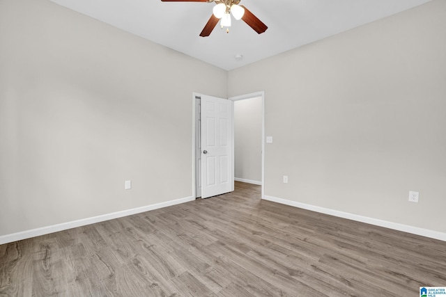 empty room with ceiling fan and light hardwood / wood-style flooring