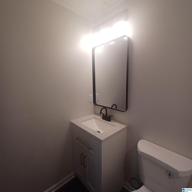 bathroom featuring vanity, toilet, and ornamental molding