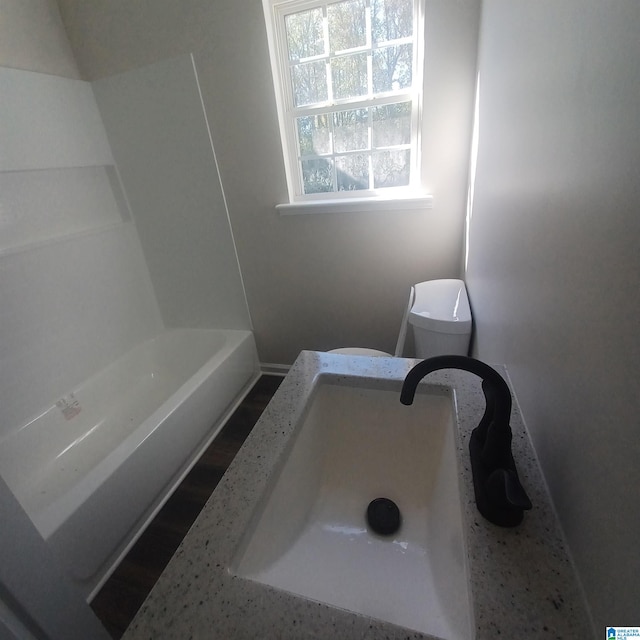 bathroom with a tub to relax in and sink