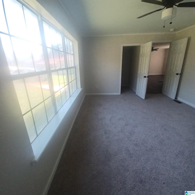 unfurnished room with ceiling fan and carpet