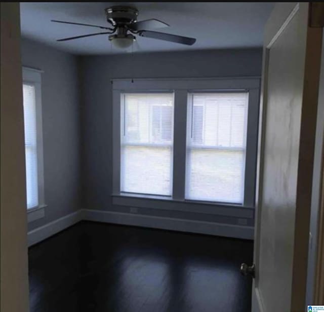 unfurnished room with dark hardwood / wood-style flooring, a wealth of natural light, and ceiling fan