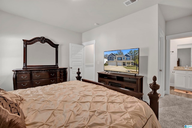 bedroom featuring ensuite bathroom and light hardwood / wood-style floors