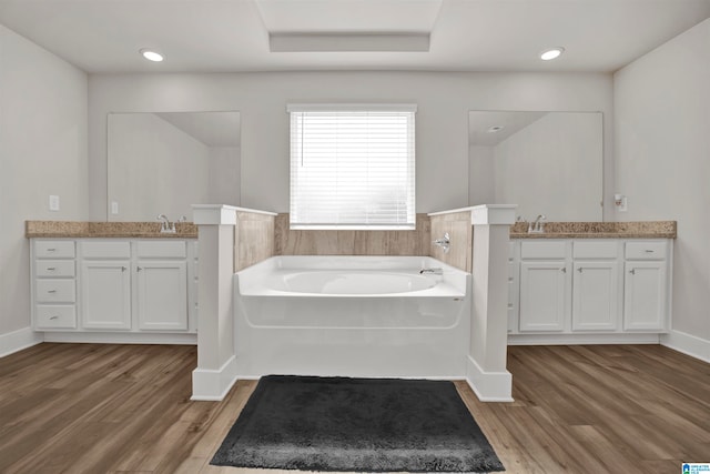 bathroom featuring vanity, a bath, and hardwood / wood-style flooring