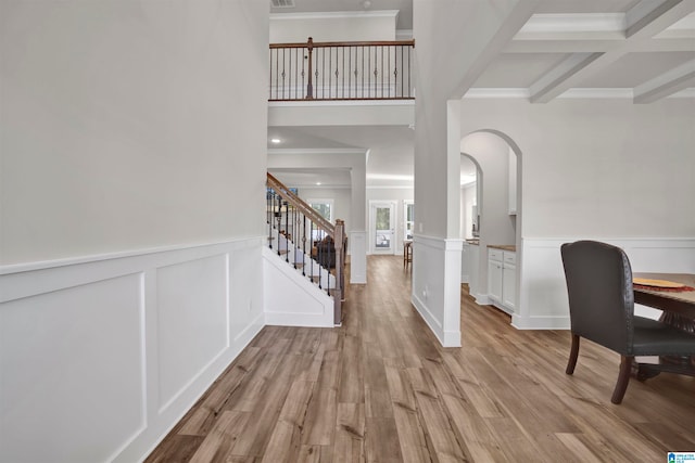 entryway with beamed ceiling, ornamental molding, light hardwood / wood-style flooring, and coffered ceiling