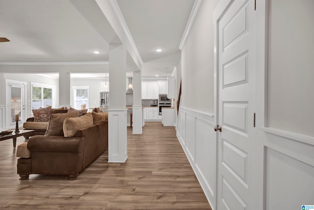 living room featuring light wood-type flooring and crown molding