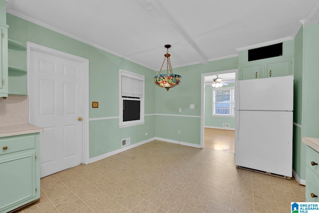 kitchen with decorative light fixtures, white fridge, ceiling fan, and crown molding