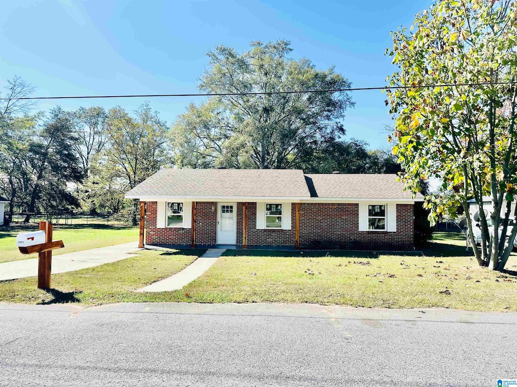 single story home featuring a front lawn