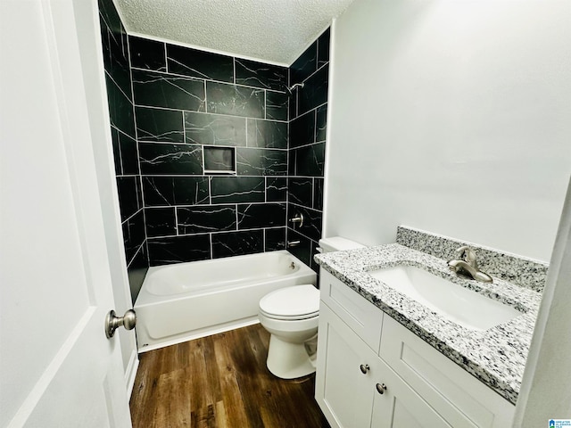 full bathroom featuring hardwood / wood-style floors, tiled shower / bath combo, a textured ceiling, and vanity