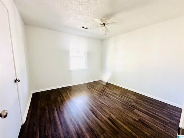 unfurnished room with ceiling fan, dark hardwood / wood-style flooring, and a textured ceiling