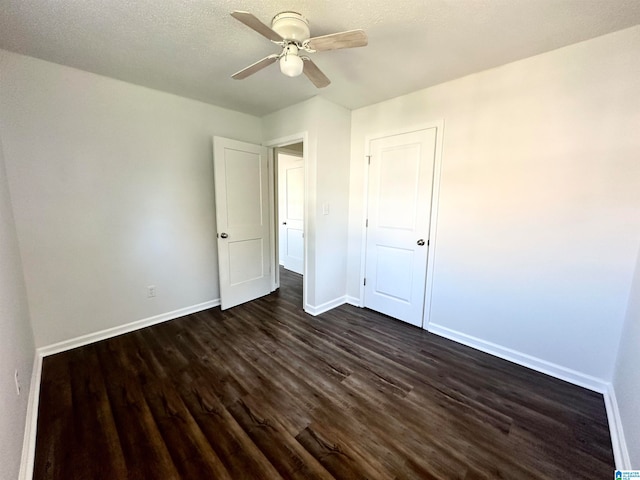 unfurnished bedroom featuring a textured ceiling, ceiling fan, and dark wood-type flooring