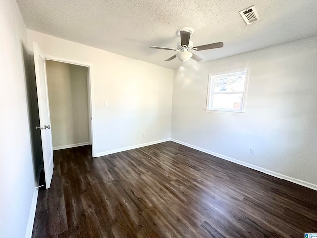 spare room with ceiling fan, dark hardwood / wood-style flooring, and a textured ceiling