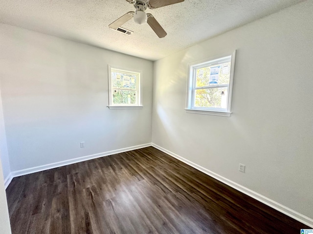 empty room with a textured ceiling, ceiling fan, and dark hardwood / wood-style floors