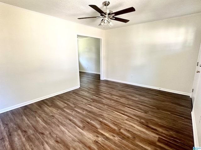 empty room with ceiling fan, dark wood-type flooring, and a textured ceiling