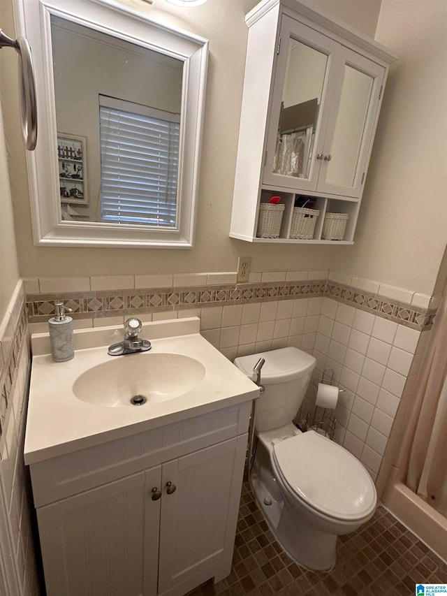 bathroom with tile patterned flooring, vanity, tile walls, and toilet