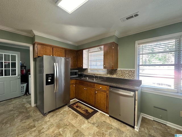 kitchen with backsplash, sink, plenty of natural light, and appliances with stainless steel finishes