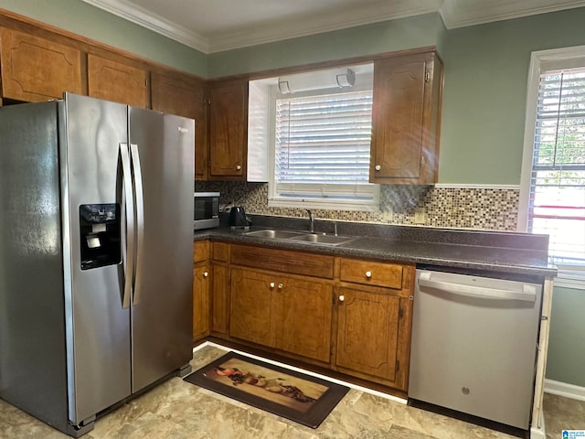 kitchen with tasteful backsplash, sink, ornamental molding, and appliances with stainless steel finishes