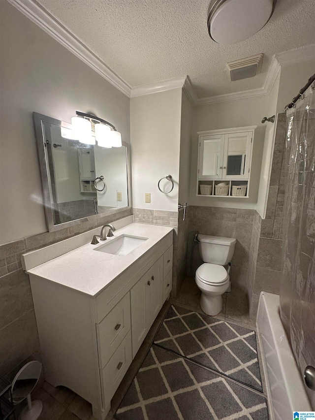 full bathroom featuring vanity, toilet, ornamental molding, a textured ceiling, and tile walls