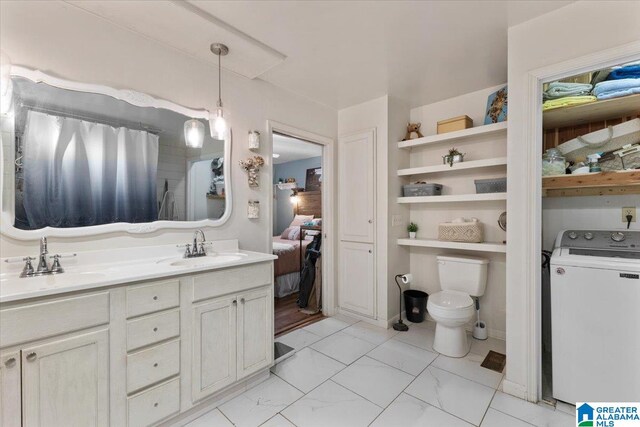 bathroom with vanity, toilet, and washer / dryer