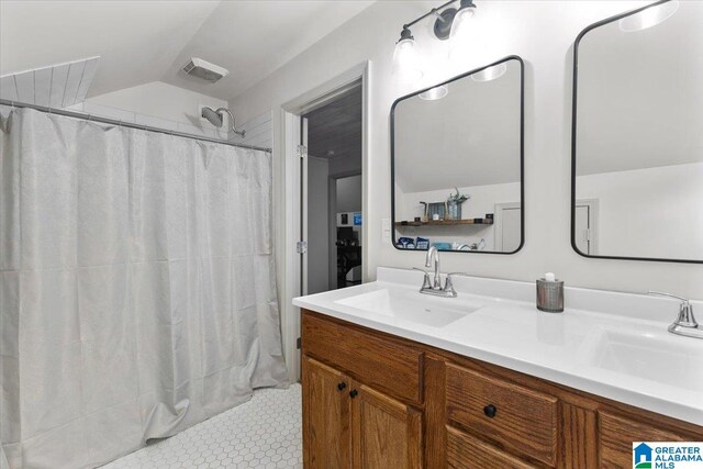 bathroom featuring tile patterned flooring, vanity, lofted ceiling, and a shower with shower curtain