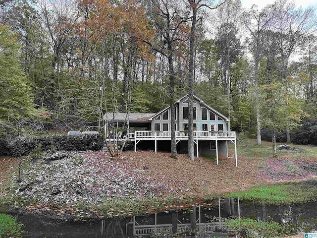 rear view of house featuring a deck with water view