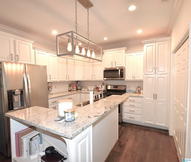 kitchen with appliances with stainless steel finishes, dark wood-type flooring, pendant lighting, a center island with sink, and white cabinetry