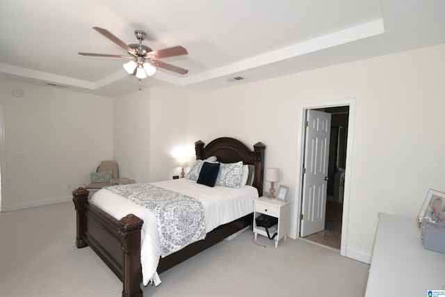 bedroom featuring light carpet, a raised ceiling, and ceiling fan