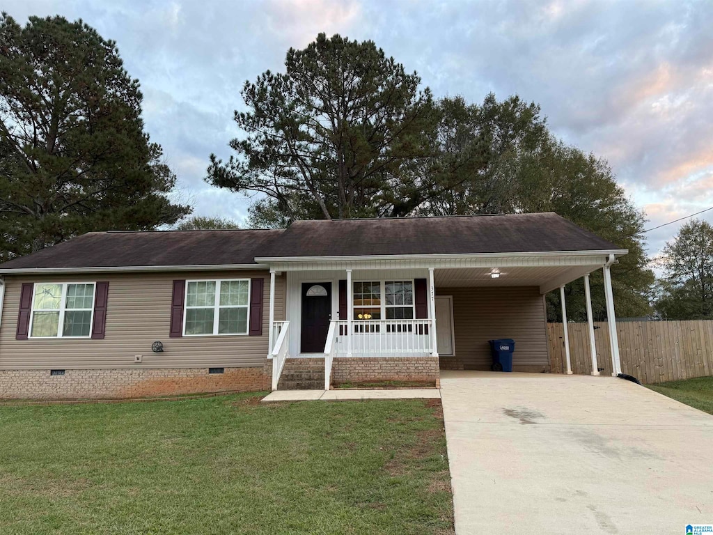 view of front of house featuring a front lawn, covered porch, and a carport