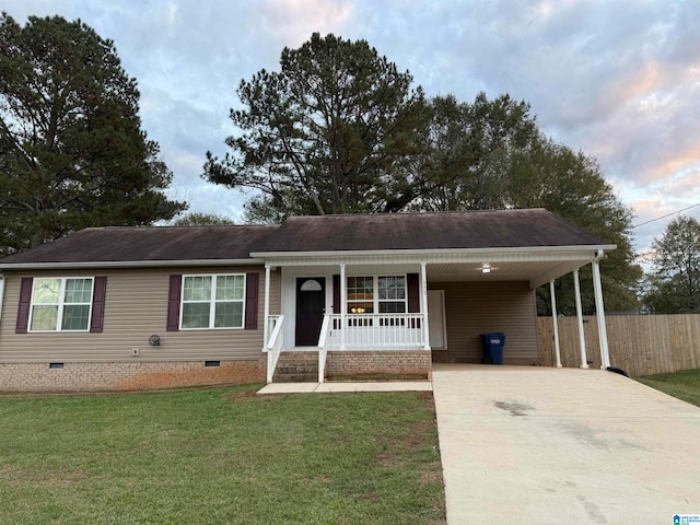 view of front of house featuring a front lawn, covered porch, and a carport