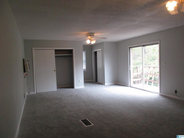 825 Goldwire St SW, Birmingham, AL 35211 - unfurnished bedroom with light colored carpet, baseboards, ceiling fan, multiple closets, and a textured ceiling