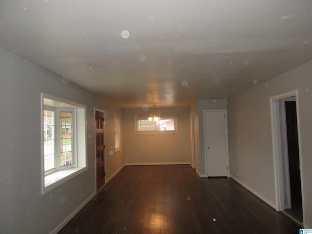 spare room featuring dark hardwood / wood-style floors and a notable chandelier