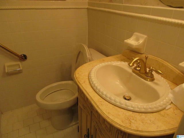 bathroom with vanity, tile walls, and toilet