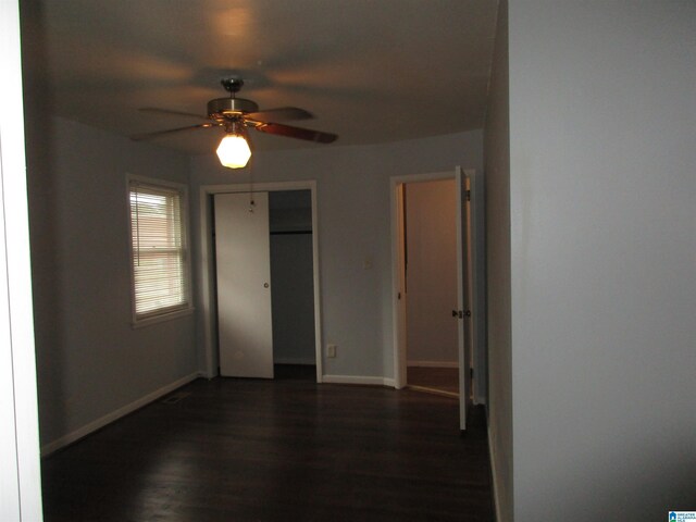 825 Goldwire St SW, Birmingham, AL 35211 - unfurnished bedroom featuring dark wood-style flooring, baseboards, a closet, and ceiling fan