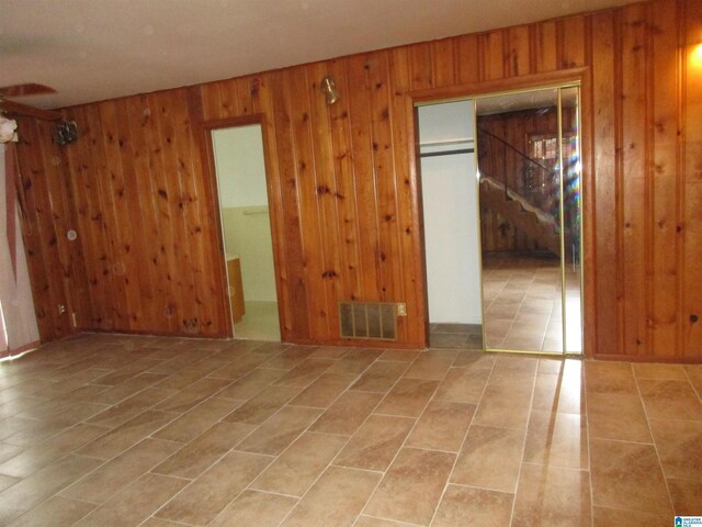825 Goldwire St SW, Birmingham, AL 35211 - empty room featuring wooden walls, stairs, and tile patterned flooring